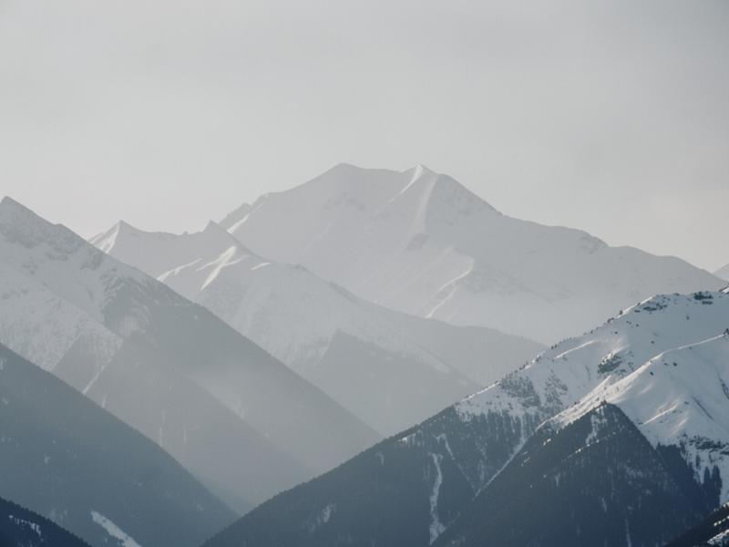 Monochrome mountain ridge under soft cloud